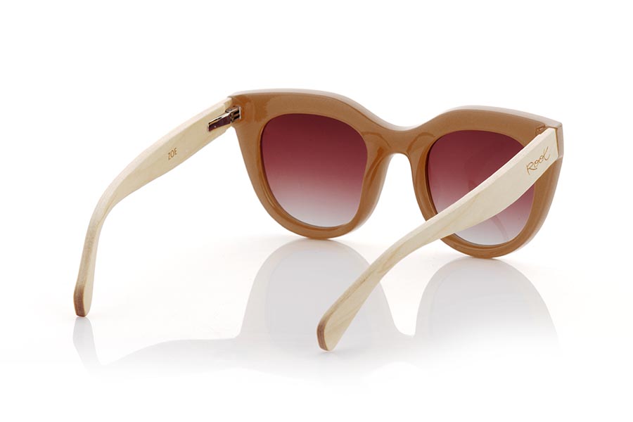 Wood eyewear of Maple ZOE. ZOE sunglasses are designed for the modern and stylish woman. With a satin transparent toasted caramel front, these sunglasses have a rounded and angled brow design that makes them unique. The maple wood temples give it a natural and sustainable touch, and the brown gradient lenses give it a sophisticated look. These sunglasses are ideal for wearing a chic style on any occasion, while protecting your eyes from the sun's UV rays. Front Measurement: 147x59mm Caliber 51 for Wholesale & Retail | Root Sunglasses® 